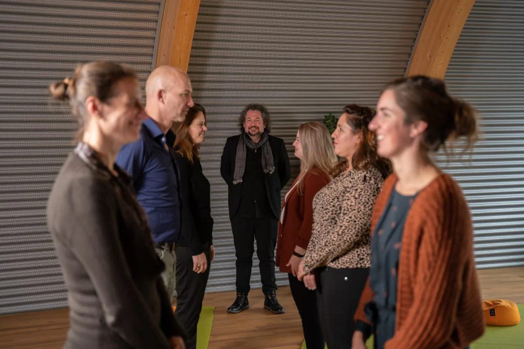 Trainer en deelnemers in gesprek na een sessie van Invivo ACT Academy